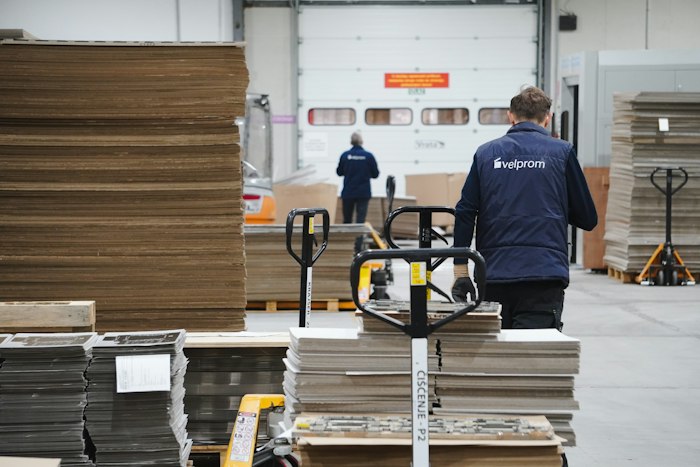 Warehouse worker moving a cart loaded with boxes