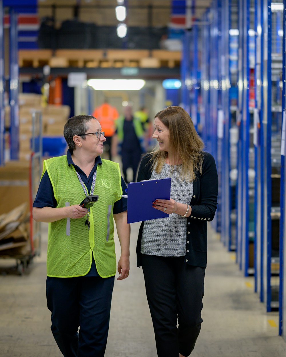 Warehouse staff member and client walking through an aisle